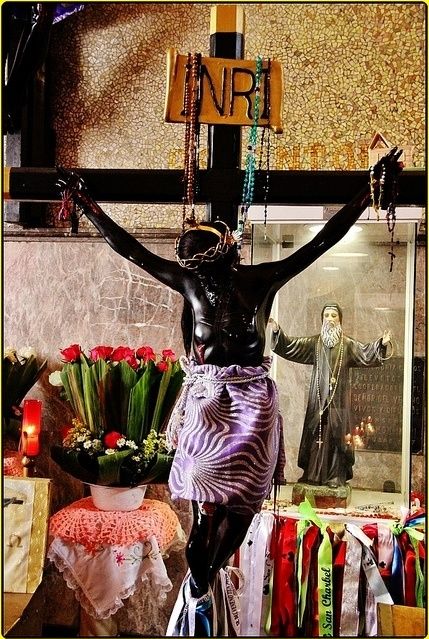 El Cristo Negro y detrás de Él una imagen de San Charbel  Makhlouf y sus cintas