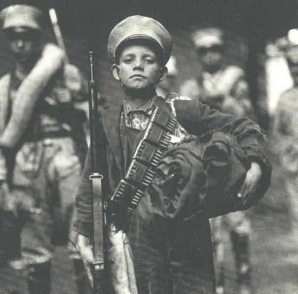 Niño soldado de la Revolución Mexicana, posa para la cámara con rifle al hombro (Wikimedia Commons).