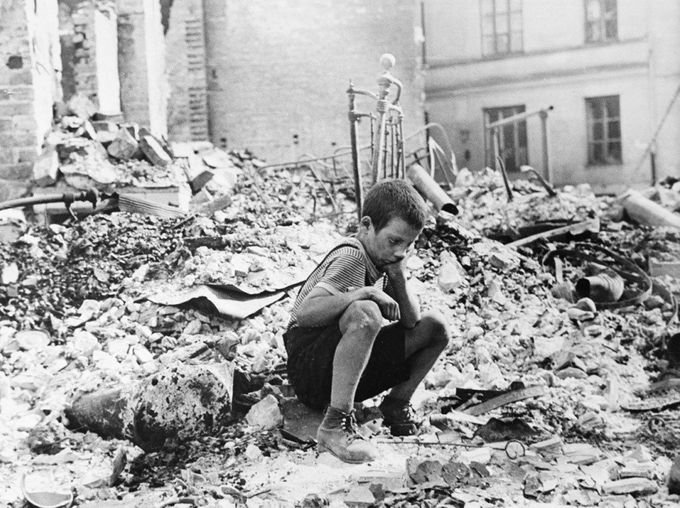 Niño sentado sobre los escombros de un edificio derrumbado por las bombas en Varsovia (Wikimedia Commons).