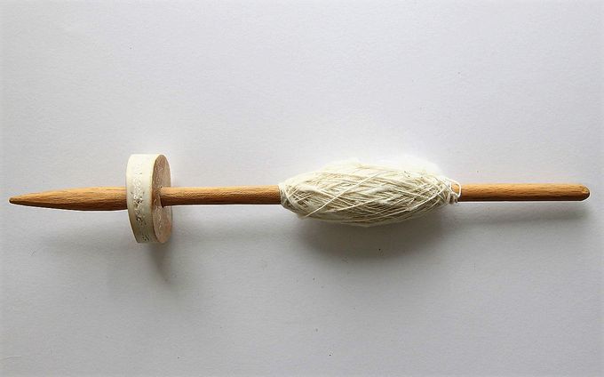Fusayola encajada en un uso con una madeja de lana